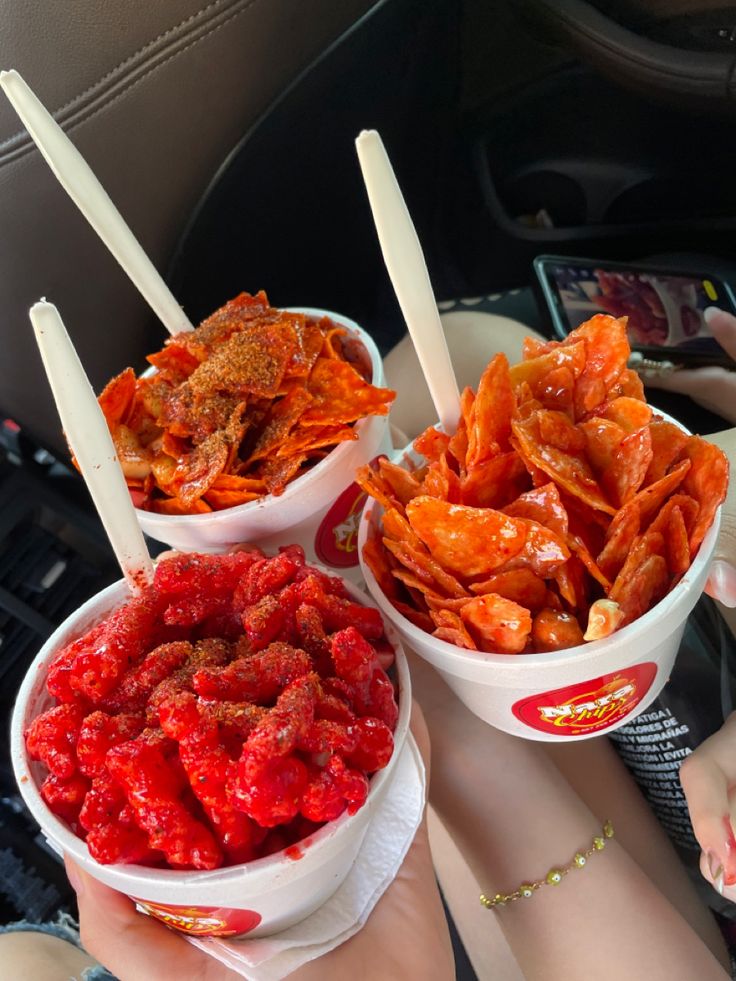 three buckets filled with different types of food on top of a car seat belt