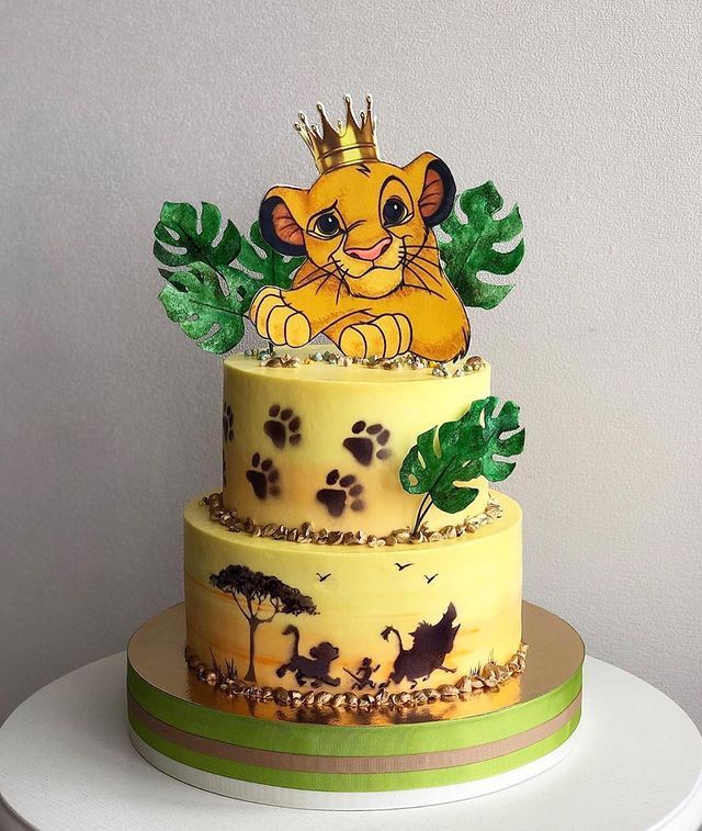 a three tiered cake decorated with an image of a lion and paw prints on it