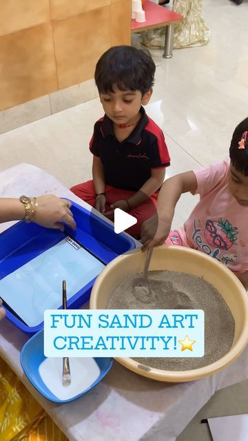 three children sitting at a table making sand art