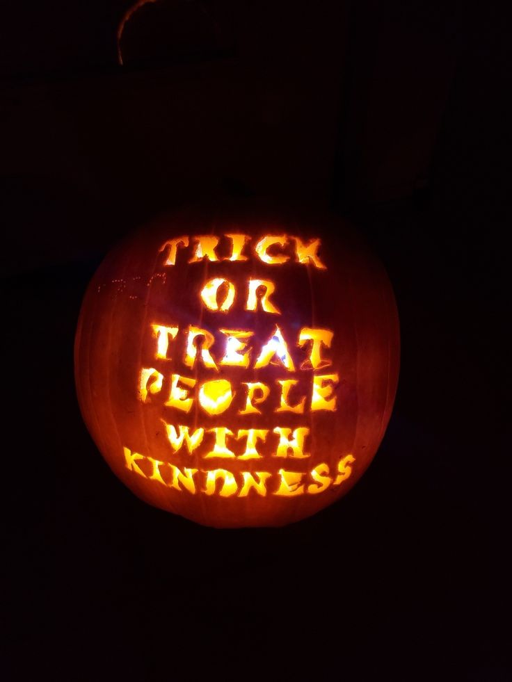 a carved pumpkin that says trick or treat people with kindness is lit up in the dark