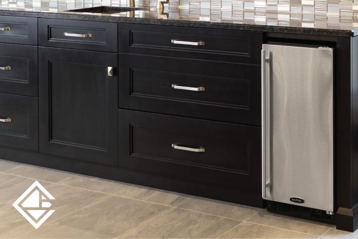 a stainless steel dishwasher is in the middle of a black kitchen cabinetry