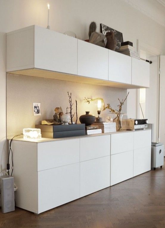 a living room with white furniture and wood flooring on top of the wooden floors