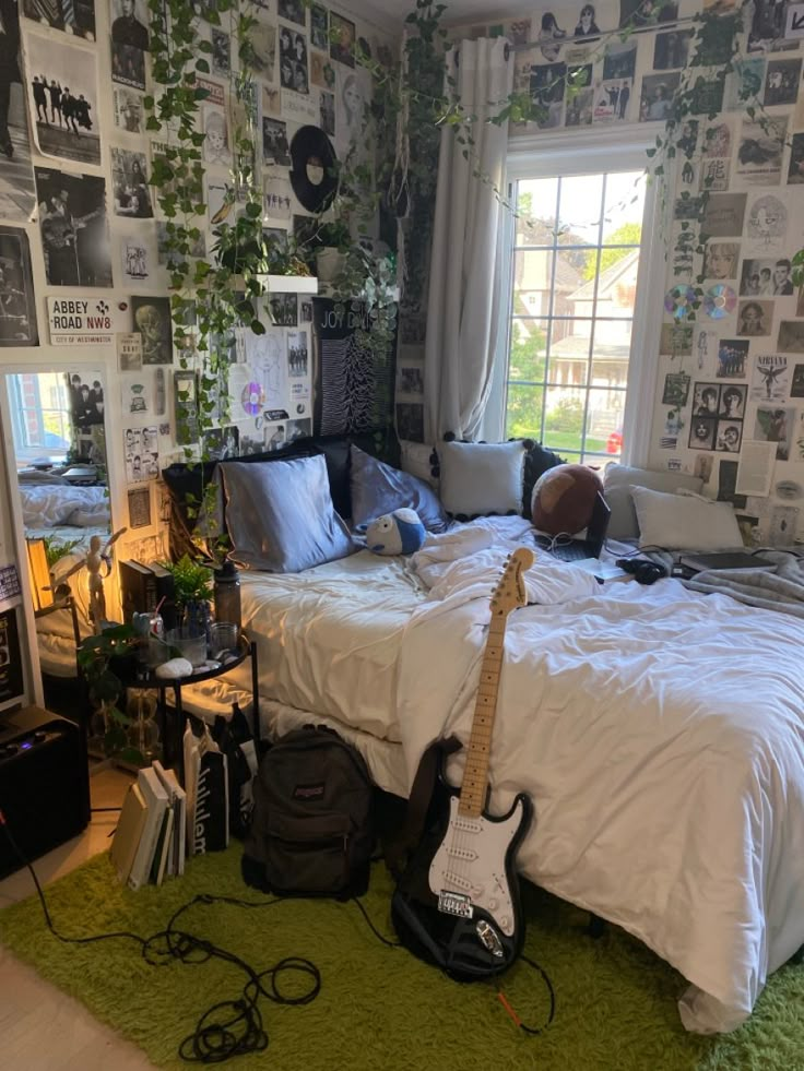 a bed room with a guitar on the floor next to a window and a green rug