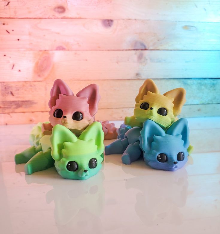 three small toy cats sitting on top of a table