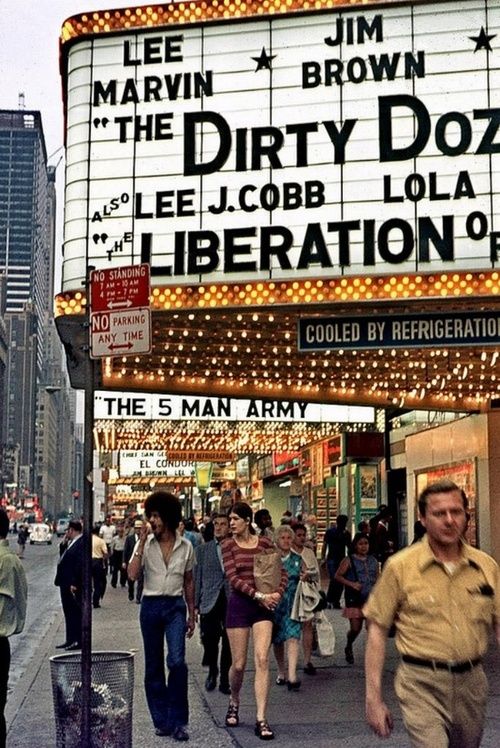 people are walking down the street in front of a theater sign that reads dirty doze liberation