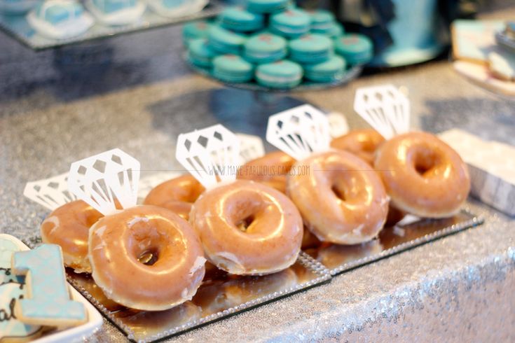 several donuts are arranged in rows on a tray at a pastry shop, ready to be eaten