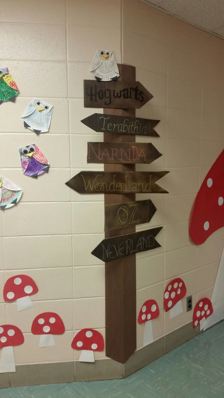 a bulletin board with many signs on it and mushrooms around the signposts in front of them