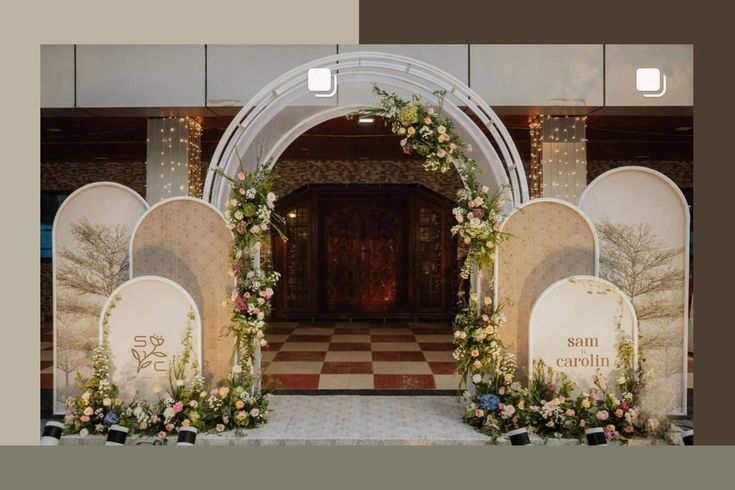 an arch decorated with flowers and greenery stands in front of a checkered floor