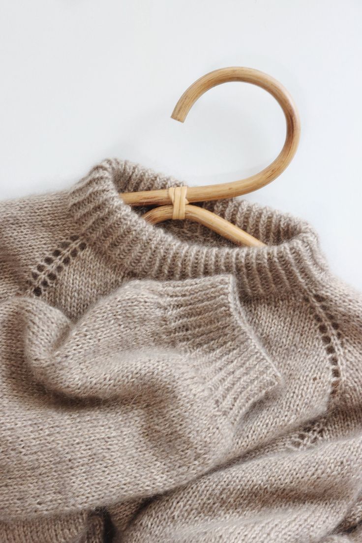 a sweater with a wooden hanger attached to it