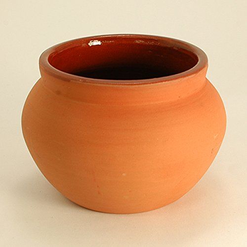 a brown vase sitting on top of a white table