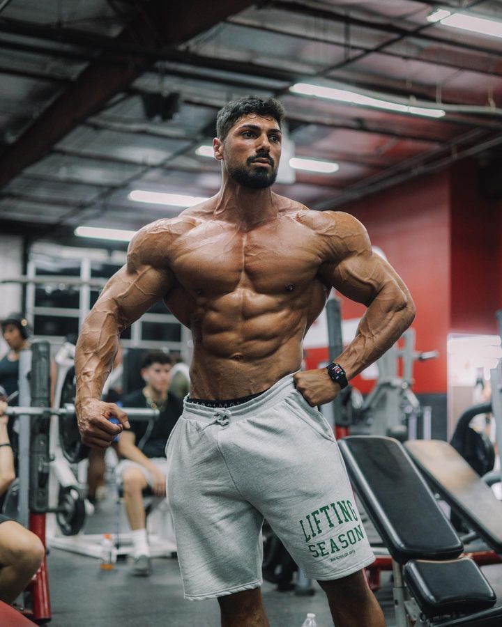 a man standing in the gym with his hands on his hips