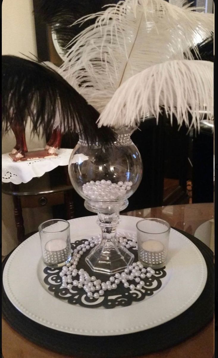 a glass vase sitting on top of a table next to two glasses and a plate