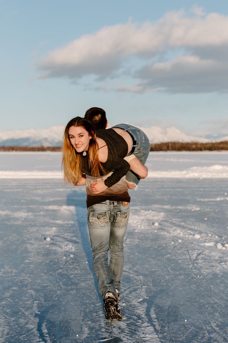 a man carrying a woman on his back in the middle of an ice covered field