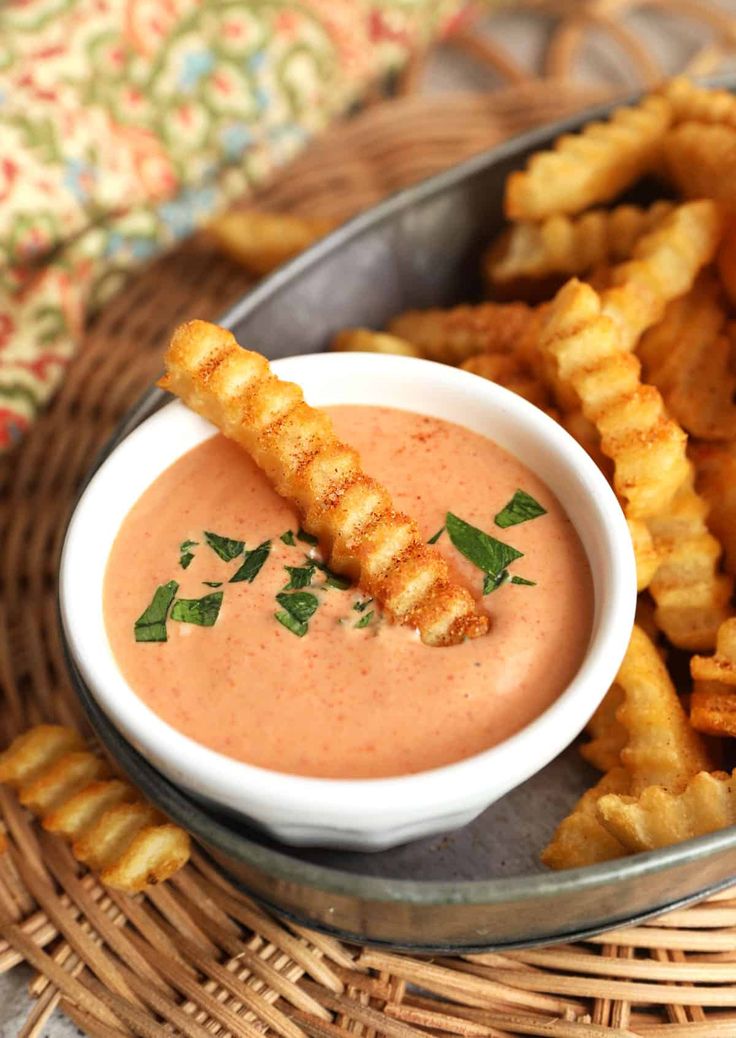 a plate with some fried food on it and dipping sauce in the bowl next to it