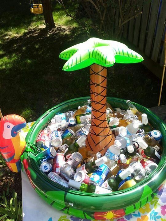 an inflatable palm tree sitting on top of a table filled with bottles and cans