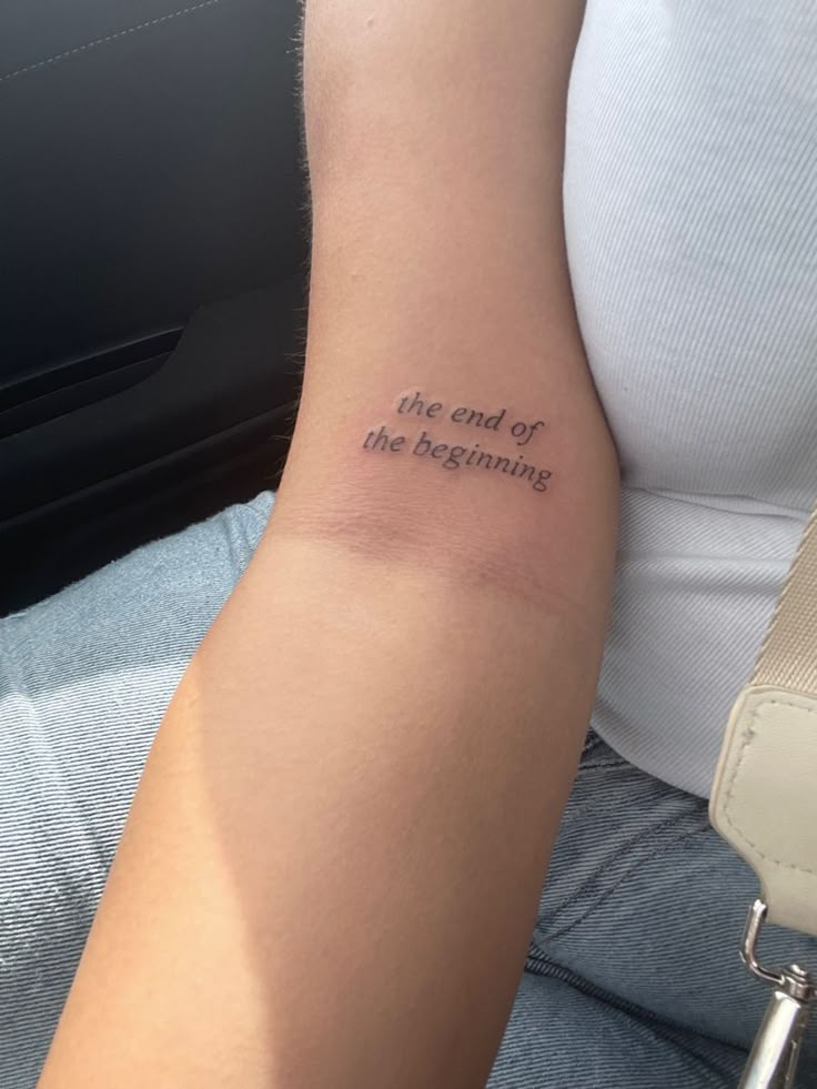 a person with a tattoo on their arm that says, the end of the beginning