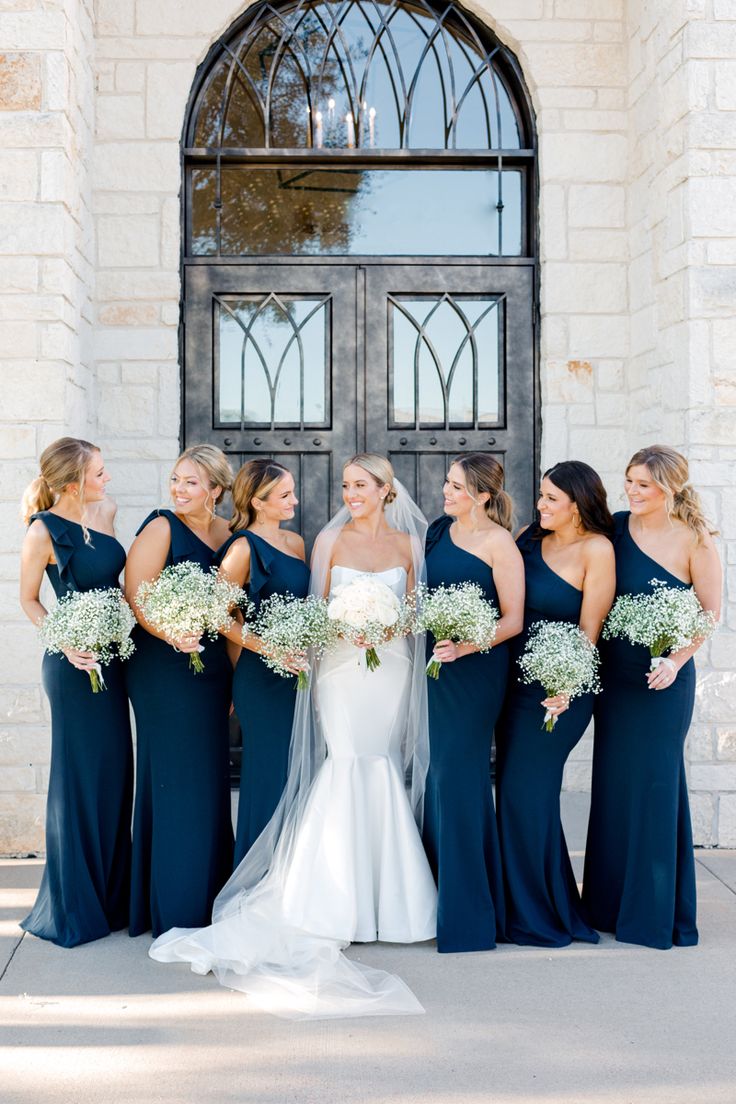 the bride and her bridesmaids pose for a photo in front of an old church door