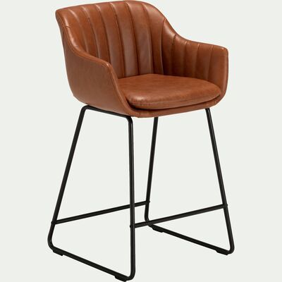 a brown leather chair with black metal legs and an upholstered back rest on a white background