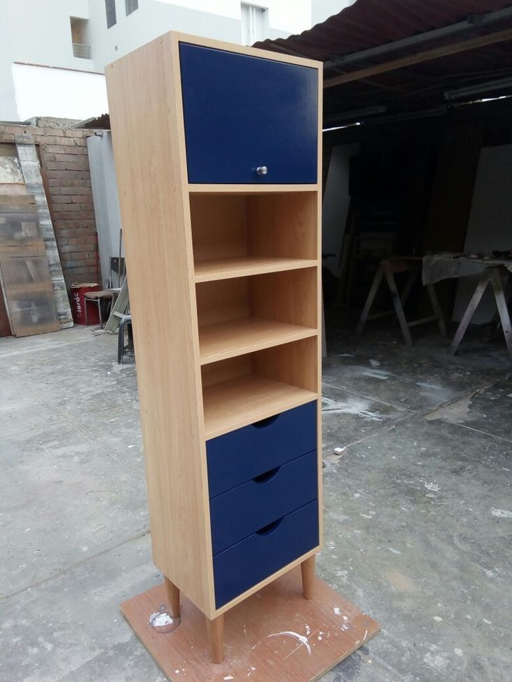 a blue and brown bookcase sitting on top of a wooden floor next to a building