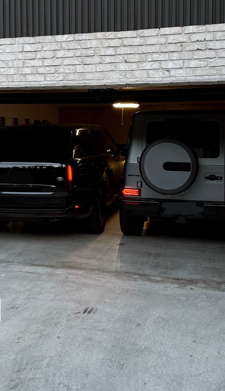 two vehicles are parked in a garage with their doors open and there is no one inside