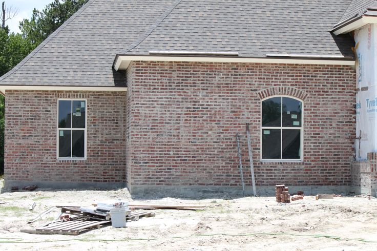 a brick house under construction next to a tree