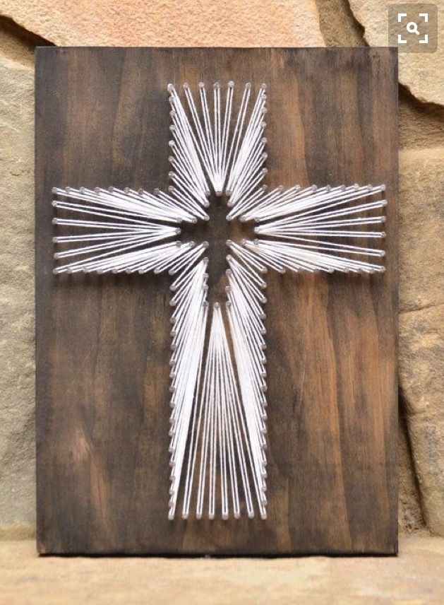 a cross made out of sticks sitting on top of a wooden board