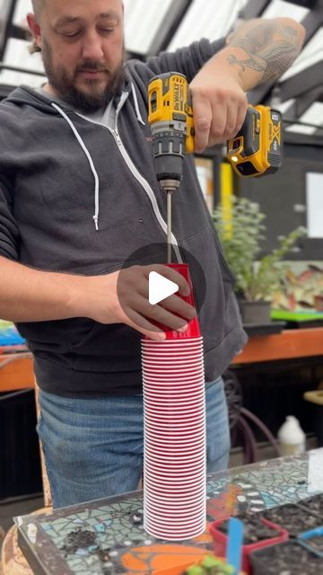 a man is working on a red tube with a screwdriver in his hand