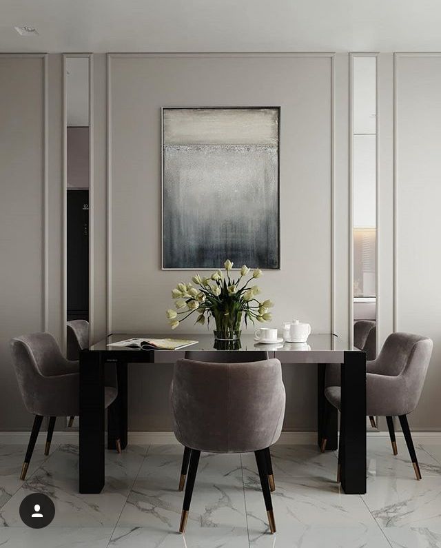 a dining room table with chairs and a vase filled with flowers on top of it