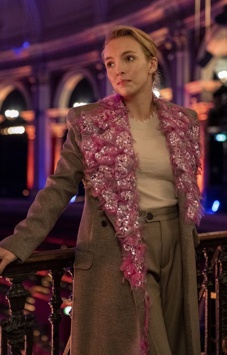 a woman is standing on a balcony with her arms out and looking at the camera