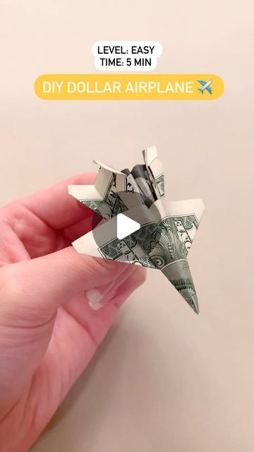 someone is holding money origami airplanes in their hand