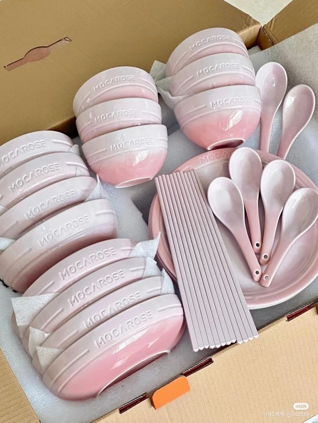 a box filled with lots of pink spoons and plates next to eachother