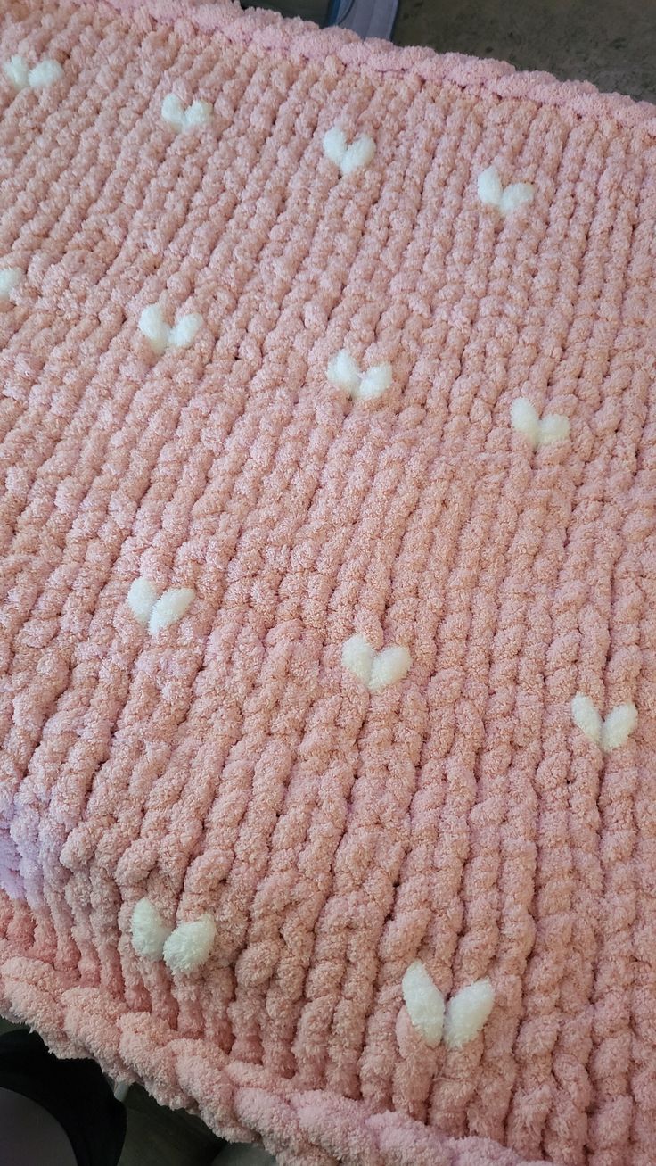 a pink blanket with white hearts on it