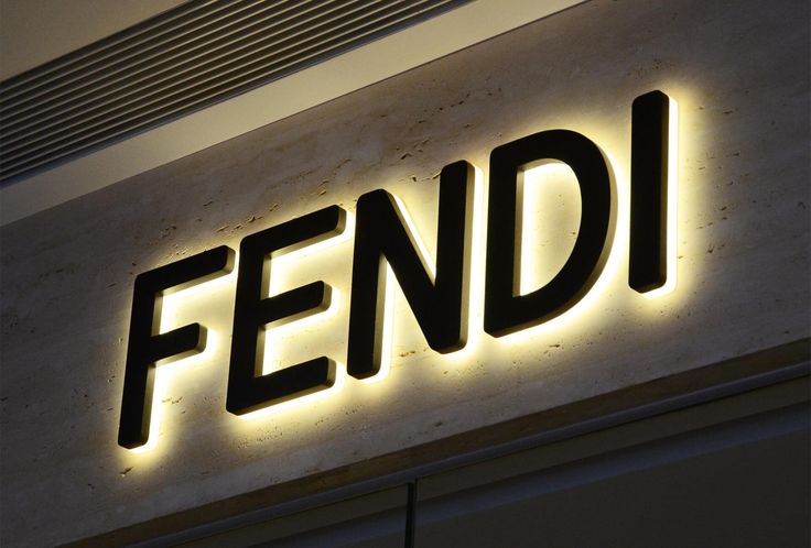 the word fendi is lit up in front of a building with an illuminated sign