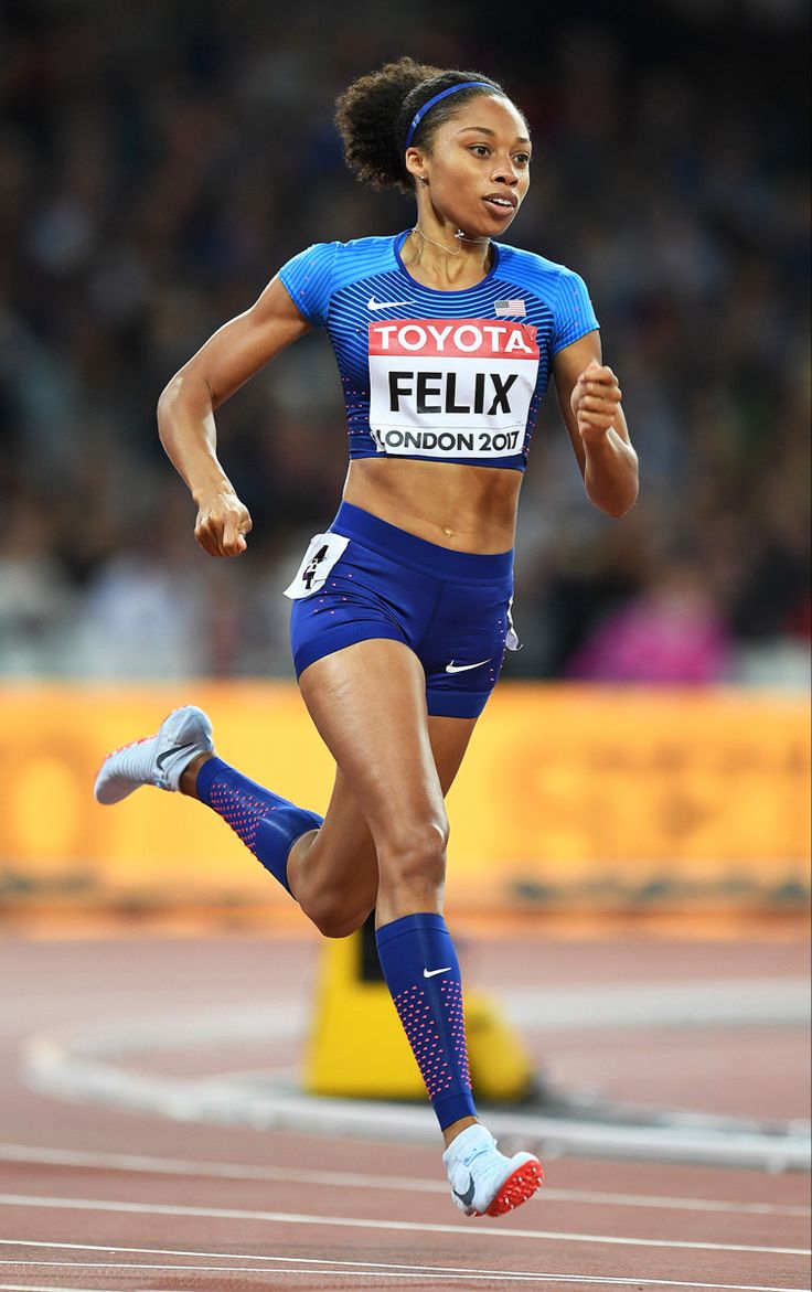 a woman running on a track in a blue outfit