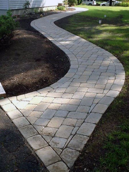 a brick walkway in front of a house