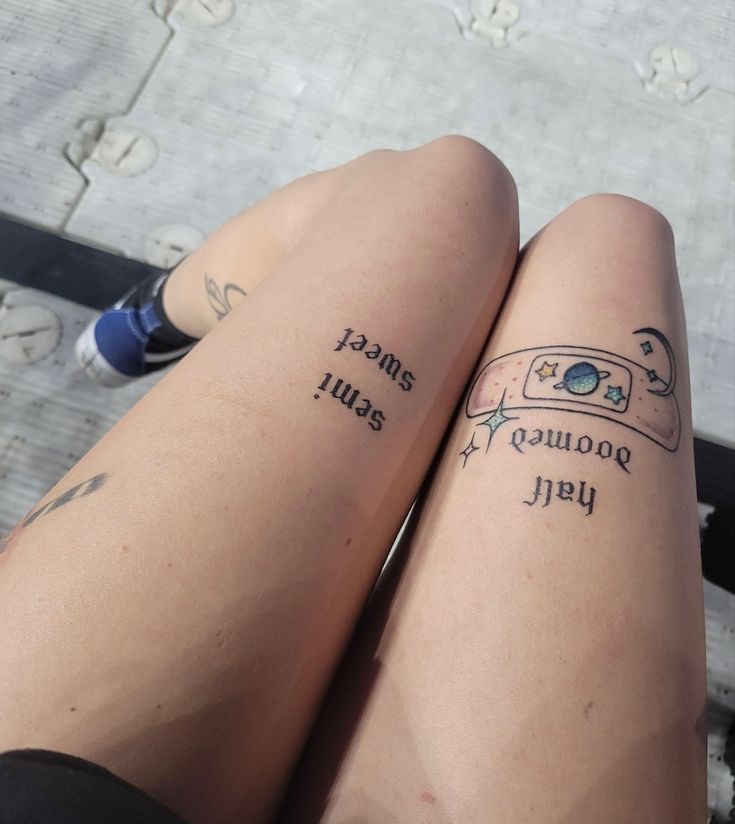 two people with tattoos on their legs sitting next to each other