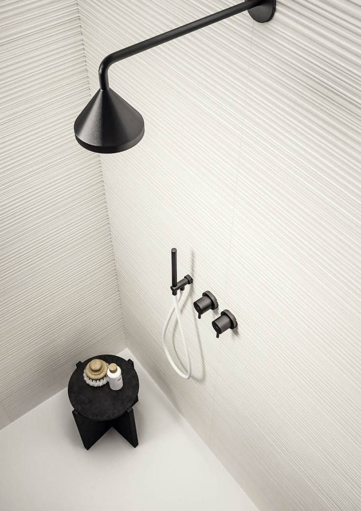 a black and white bathroom with a shower head, soap dispenser and two faucets