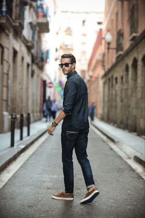 a man standing in the middle of an alleyway with his hand on his hip