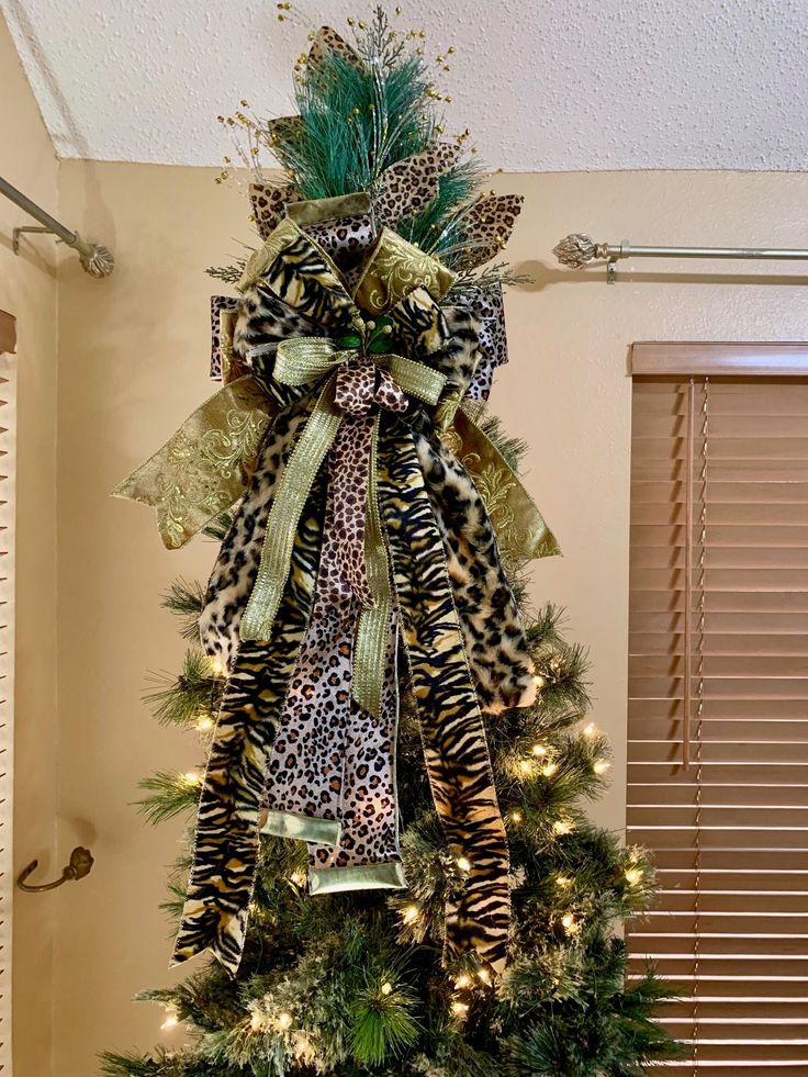 a christmas tree decorated with leopard print ribbon and lights