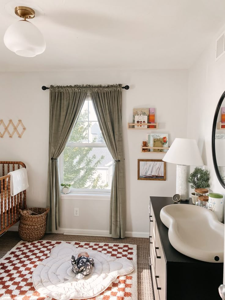 a baby's room with a crib, sink and window