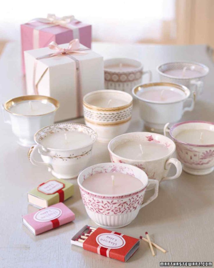 a table topped with cups and saucers next to a box filled with candy canes