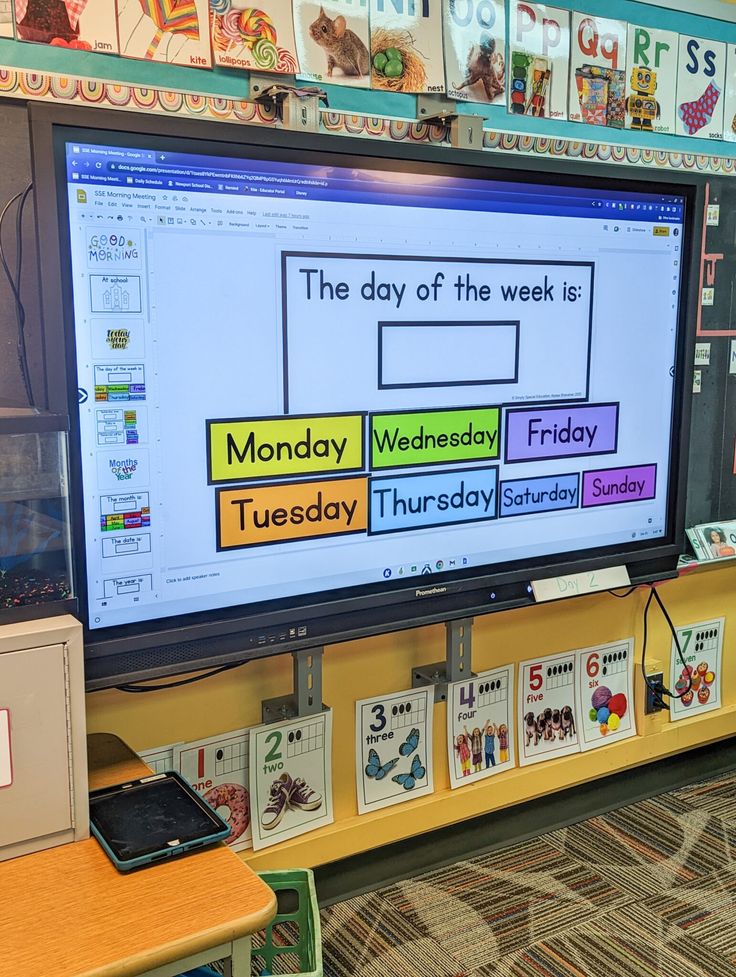 a classroom with a big screen tv and lots of books on the shelves in front of it