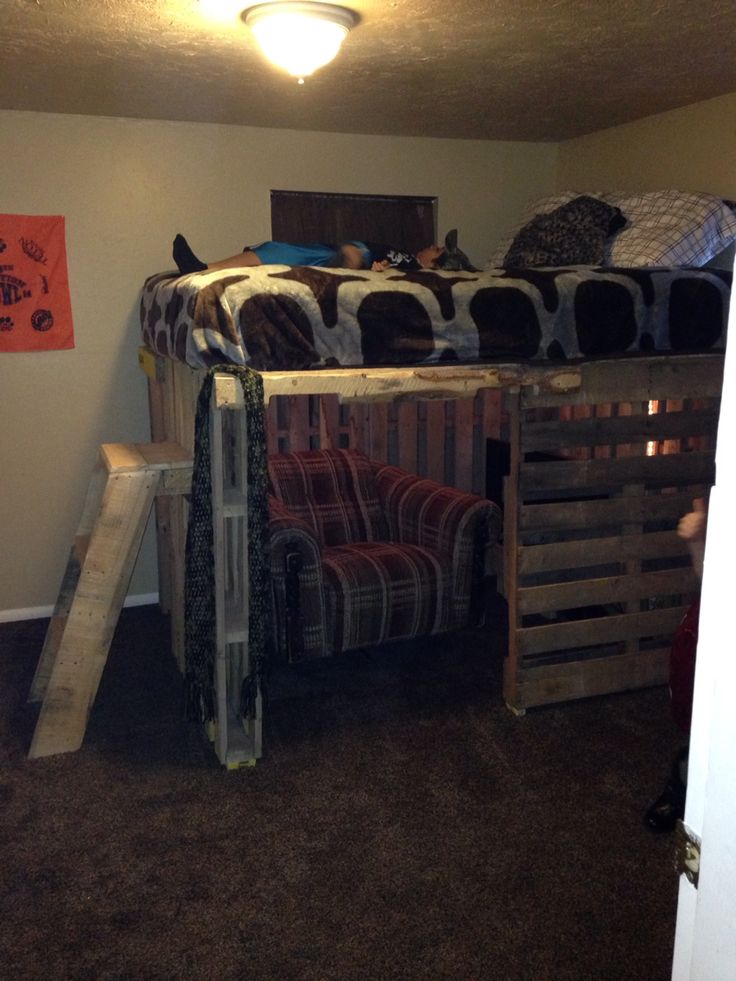 a bunk bed made out of pallets in a room with carpeted flooring