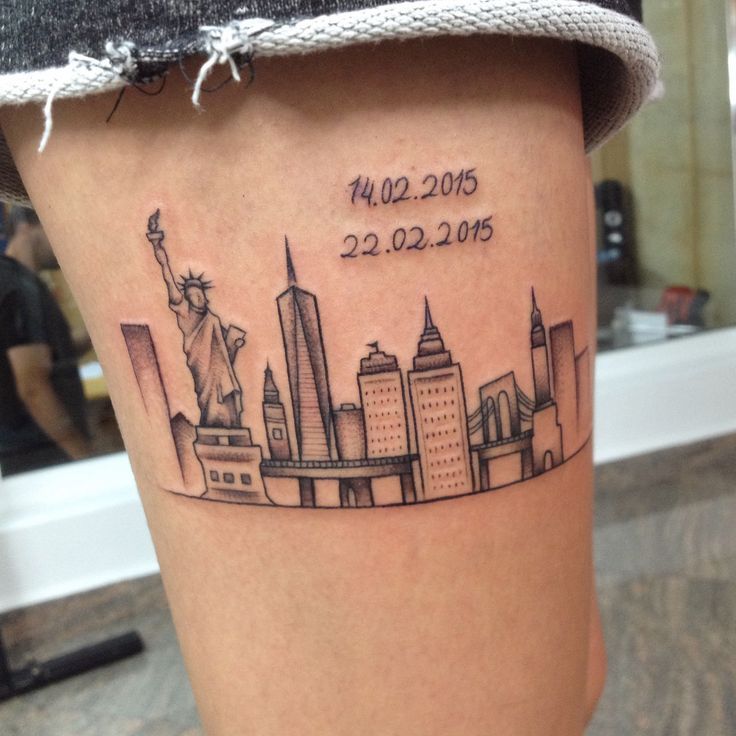 a woman's leg with a city skyline tattoo on the side of her thigh