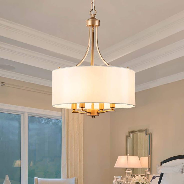 a chandelier hanging over a bed in a room with white walls and furniture