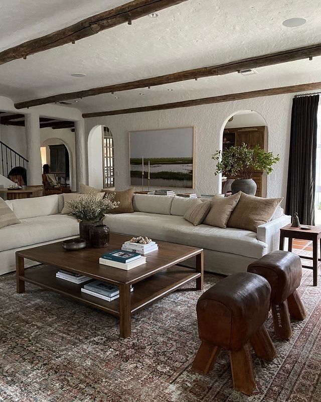 a living room filled with furniture and a large rug on top of a wooden floor