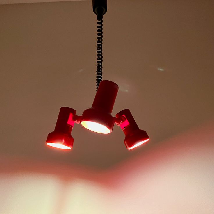 three red lights are hanging from the ceiling