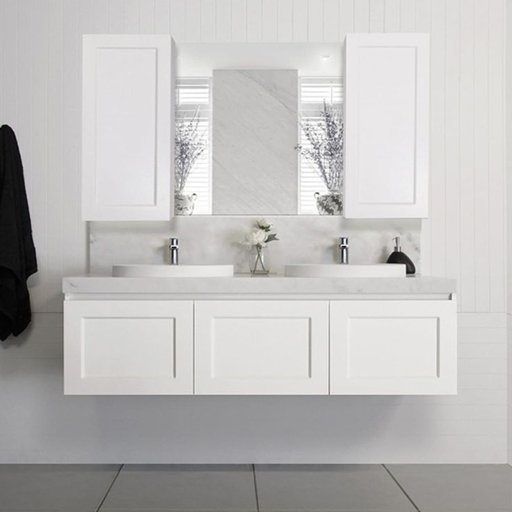 a bathroom with two sinks and mirrors on the wall