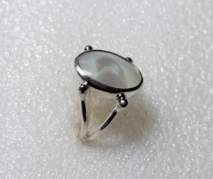 Mother of Pearl Ring in Sterling and Fine Silver by SmithSilver size 8 & 1/2 Mother of Pearl is produced by some mollusks as an inner shell layer; it also makes up the outer coating of pearls. It is strong, resilient, and iridescent. It is said to attract prosperity. Live long and prosper! The oval MOP cabochon measures 12 X 18mm.   Band is two strands of round Sterling Silver, balled at the fine silver bezel attachment point giving the appearance of grasping the stone. Last photo shows the back side and my SmithSilver stamp of authenticity. Your ONE-OF-A-KIND Ring will arrive in a Silver Gift Box USPS FIRST CLASS Package rate includes tracking & insurance for your assurance! SEE ALL MY RINGS AT: https://www.etsy.com/shop/SmithSilver925?ref=listing-shop2-all-items-count&section_id=19389415 Live Long And Prosper, Mother Of Pearl Ring, Aquarius Season, Lubbock Tx, Jewelry Board, Silver Gift Box, Jewelry Boards, Shiny Things, Pretty Rings