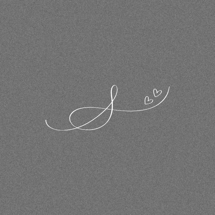 the word love is written in white ink on a gray background with two small hearts